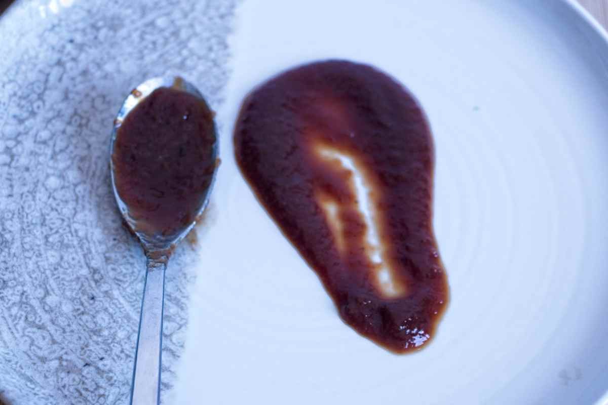 Homemade brown sauce recipe showing thick, glossy texture on a plate and spoon