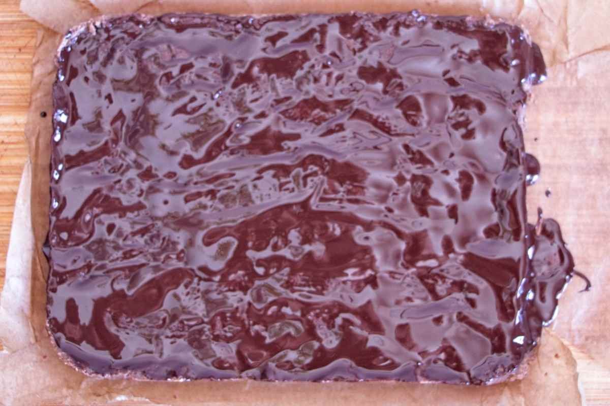 Melted chocolate spread over the protein bar mixture before chilling