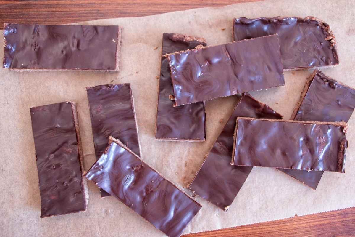 Chocolate peanut butter protein bars cut into pieces with a smooth chocolate topping