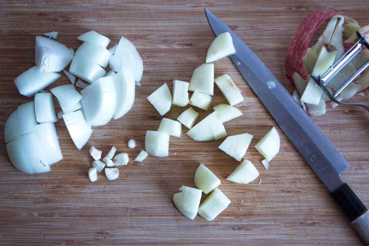 Chopped onion, garlic and apple prepared on a board for brown sauce