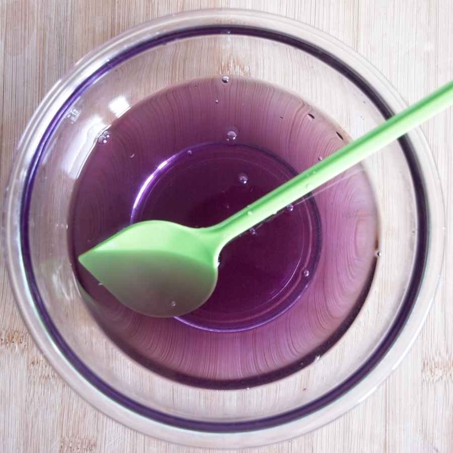 Violet syrup showing colour change from blue to purple in a glass bowl with spoon