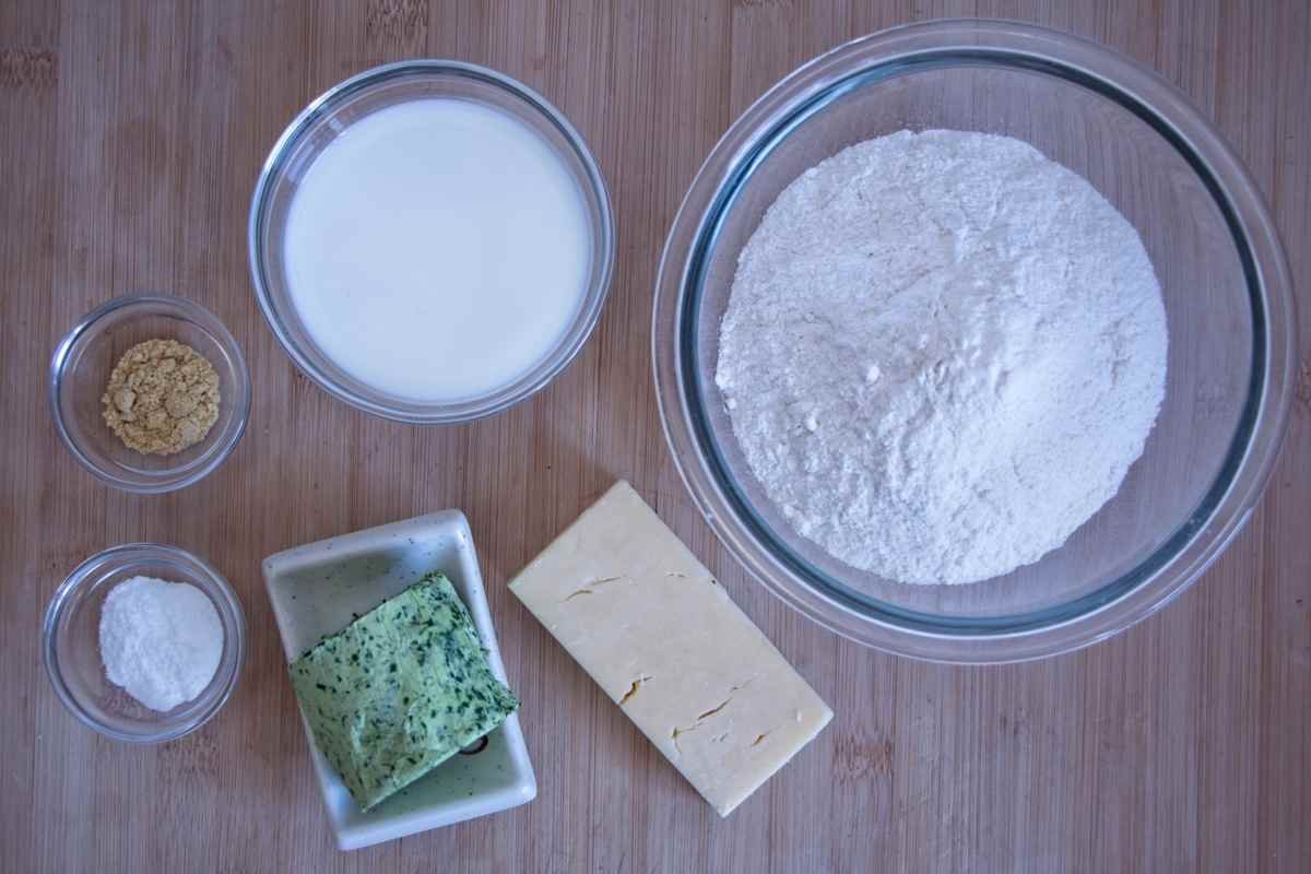 Ingredients for making wild garlic scones including flour, milk, wild garlic butter, cheese, and seasoning