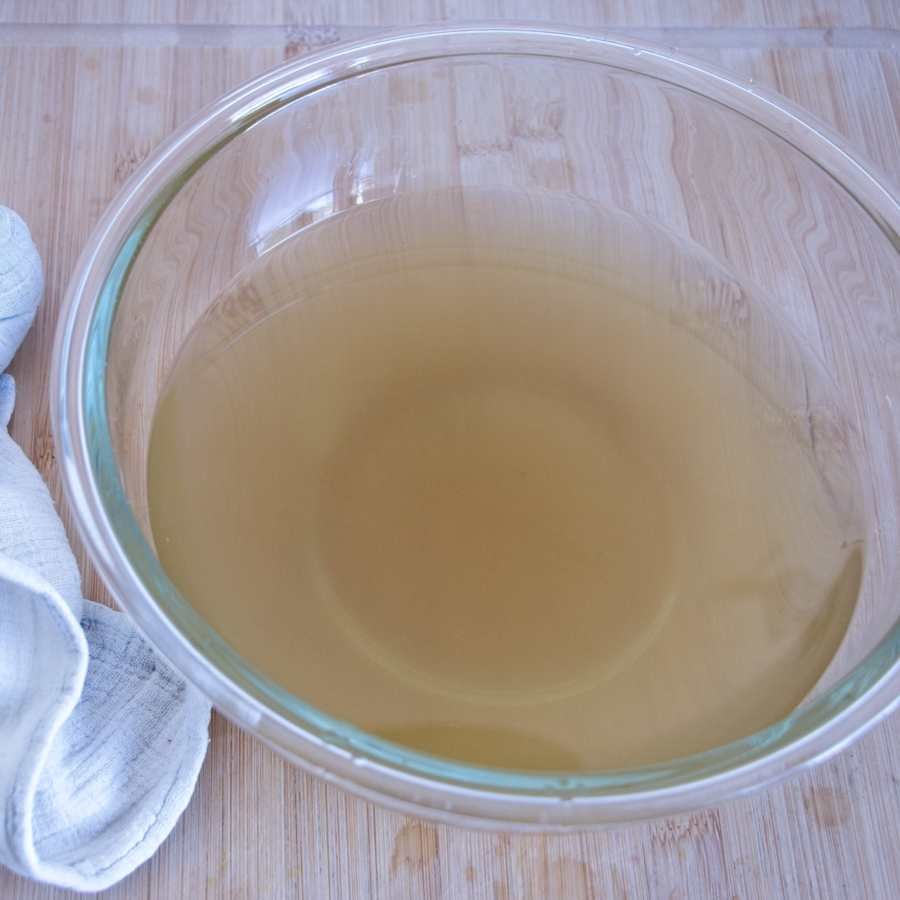 strained dandelion liquid in glass bowl
