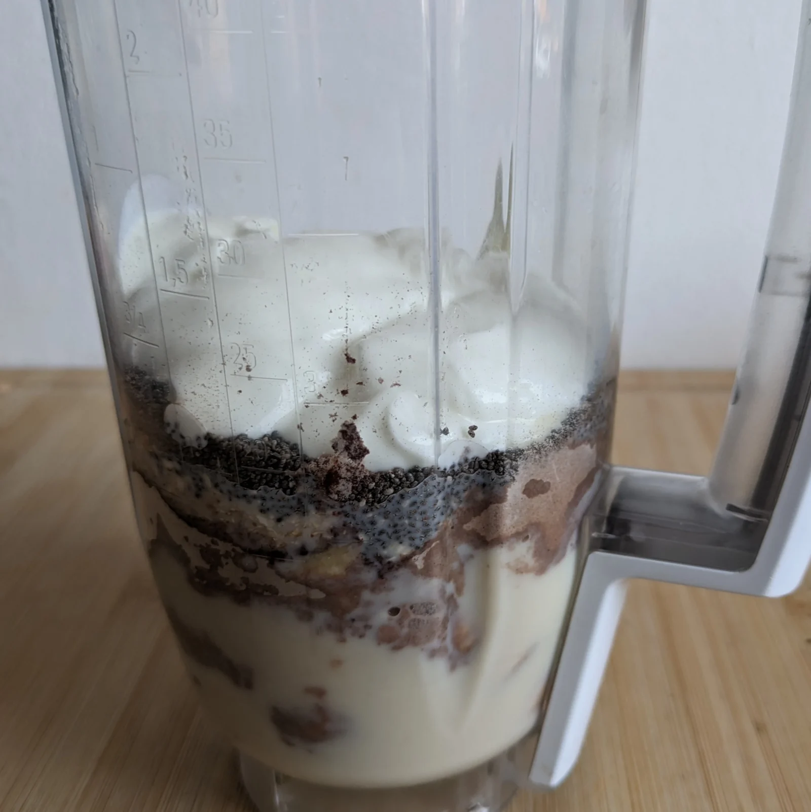 Ingredients for a high protein breakfast smoothie layered in a blender before blending.