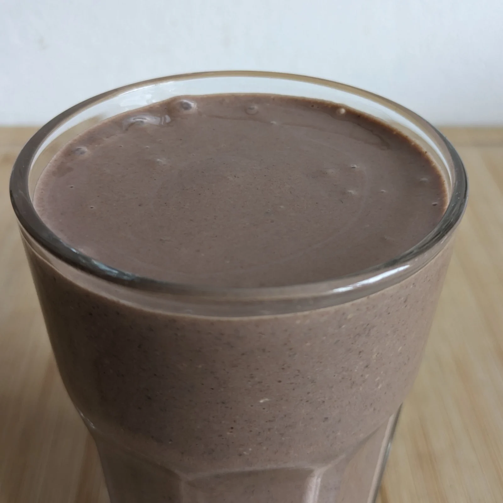 Close-up of a chocolate high protein breakfast smoothie in a glass.