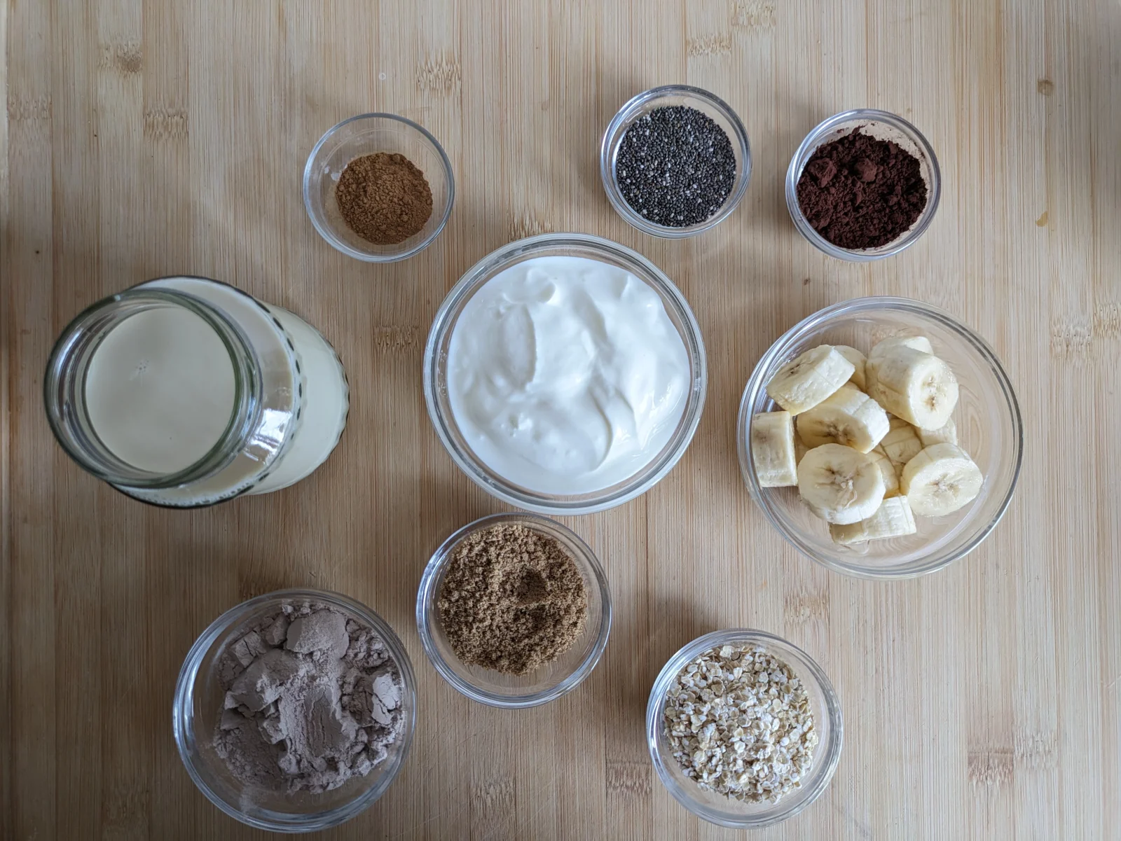 Ingredients for a high protein breakfast smoothie including Skyr, soy milk, banana, oats, chocolate protein powder, cocoa powder, chia seeds, ground flaxseed and cinnamon.