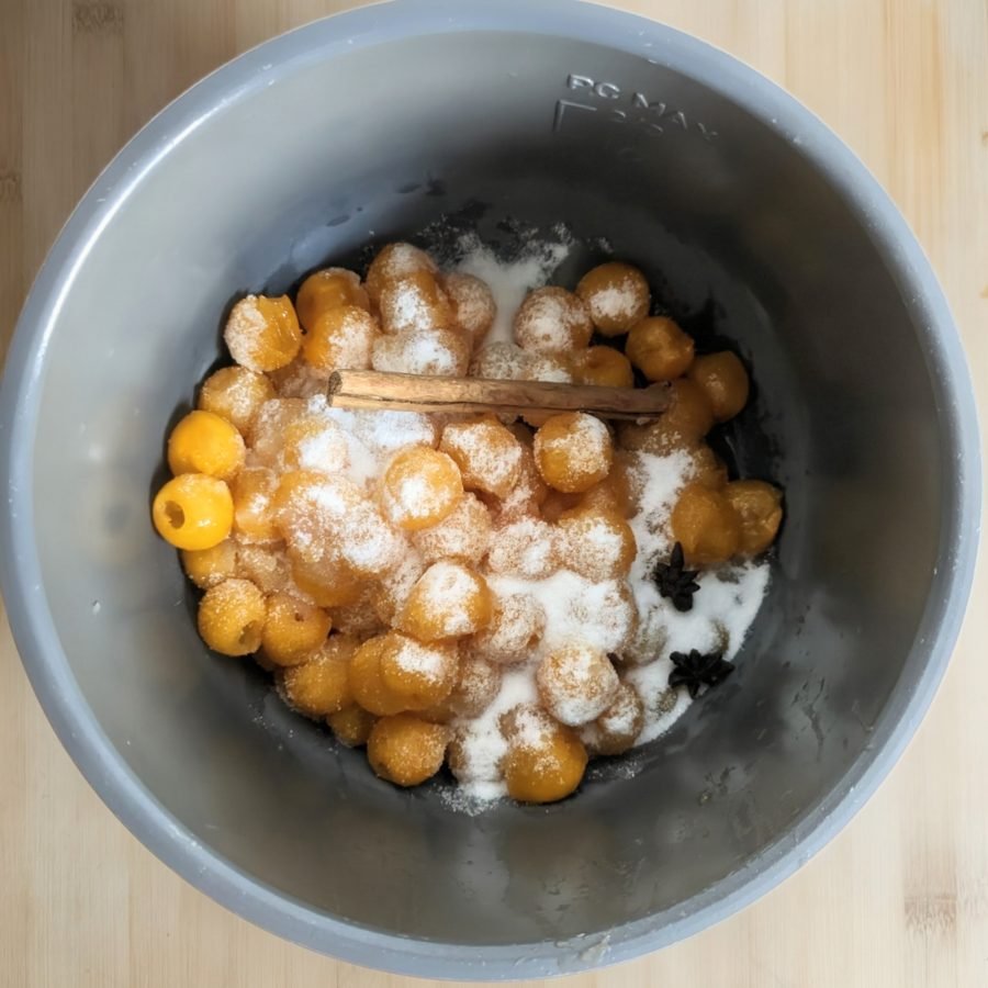 Mirabelle plums, sugar and whole spices added to the slow cooker before making spiced plum butter.