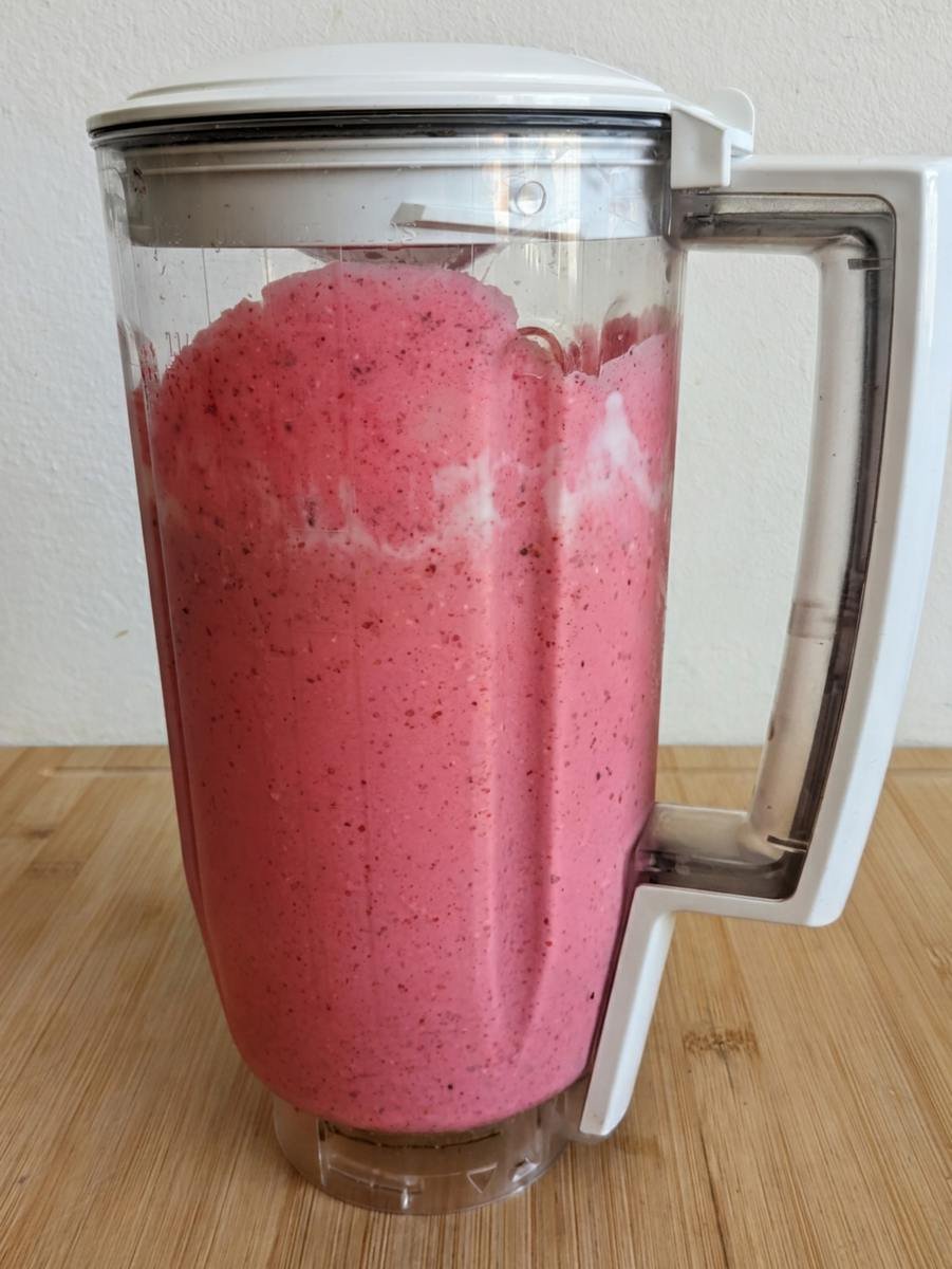 Thick blended berry smoothie mixture ready to pour into bowls.