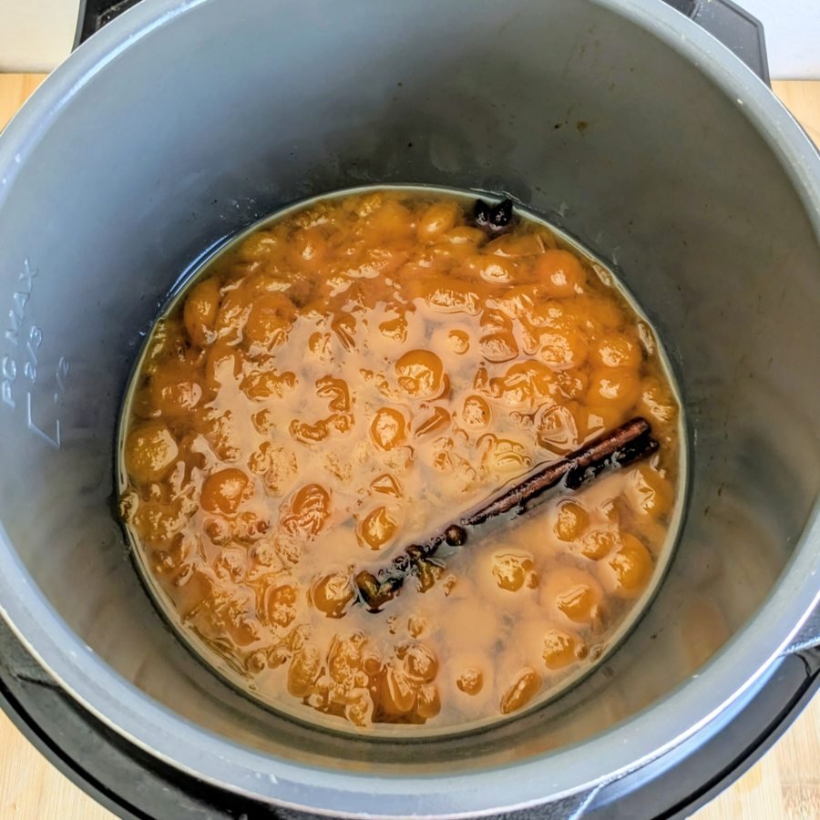 Mirabelle plums cooking with cinnamon, star anise and cardamom in the slow cooker before blending into plum butter.