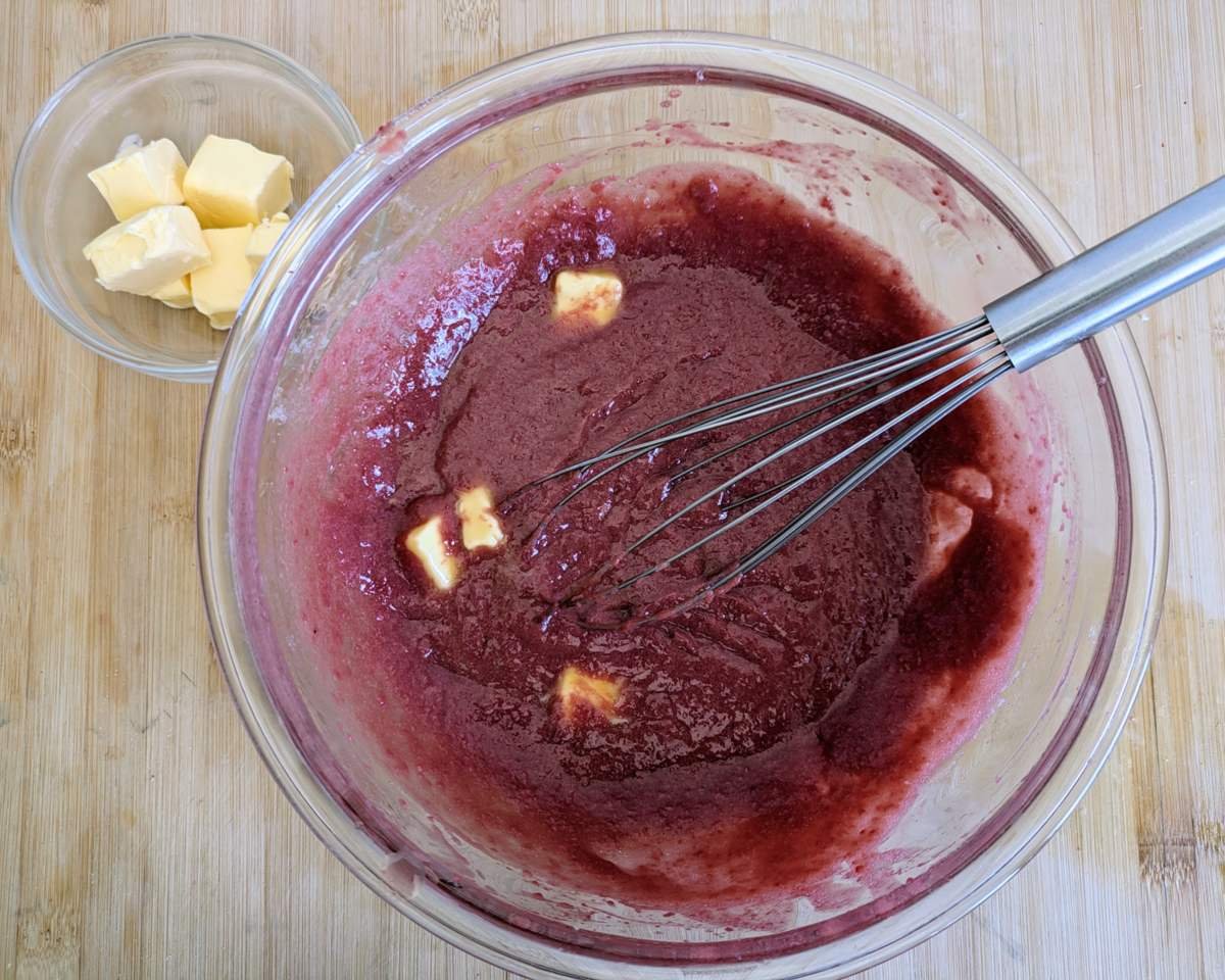 Butter being whisked into the fruit curd mixture.