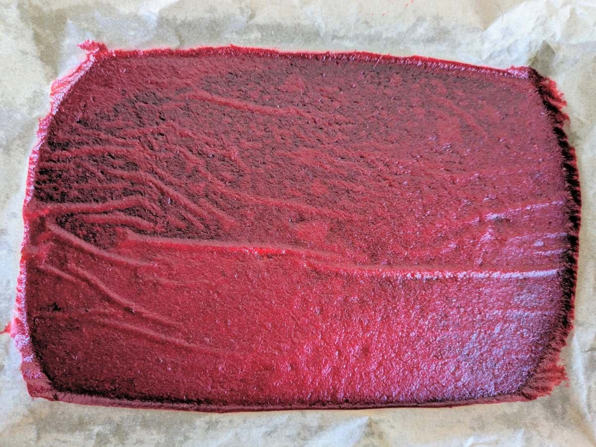 Dried Cornelian cherry fruit leather on baking parchment before cutting into strips.
