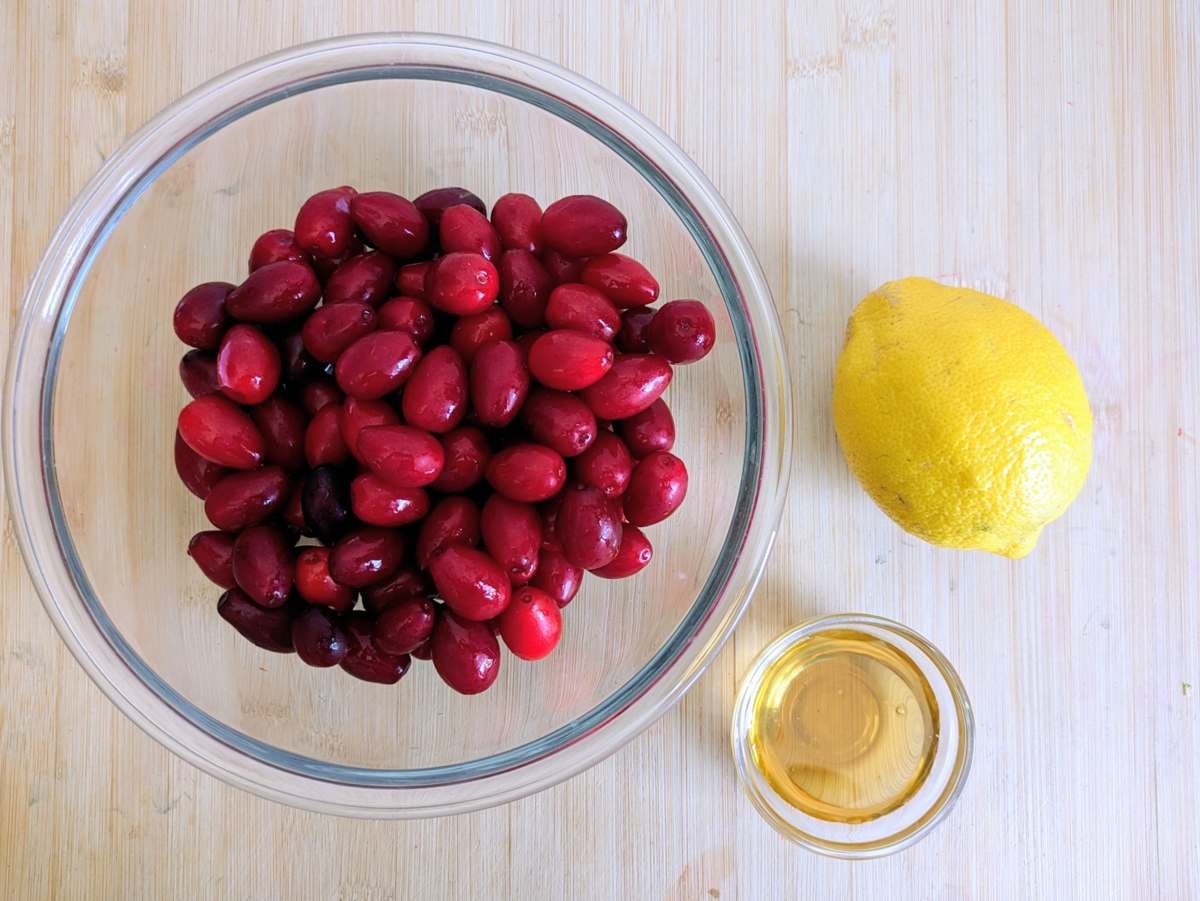 Cornelian cherries, lemon and syrup for making homemade fruit leather.