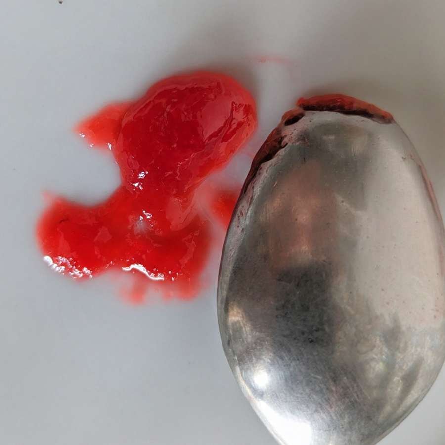 Cornelian cherry jam on a chilled plate showing the wrinkle test for setting.