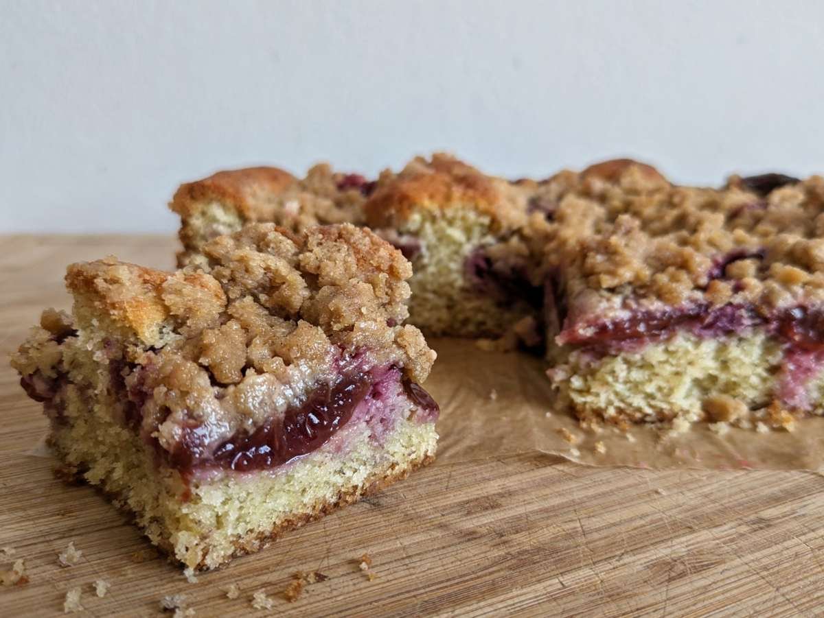 Prune plum crumble cake slice with a juicy plum centre and crisp cinnamon streusel topping.