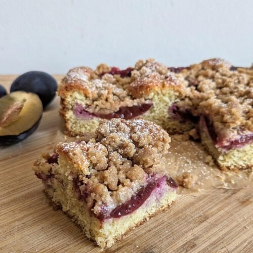 Prune plum crumble cake cut into squares with juicy plum layers and a crisp streusel topping.
