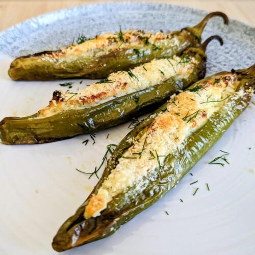 Stuffed Anaheim peppers with feta, golden breadcrumbs and chopped dill on a plate.