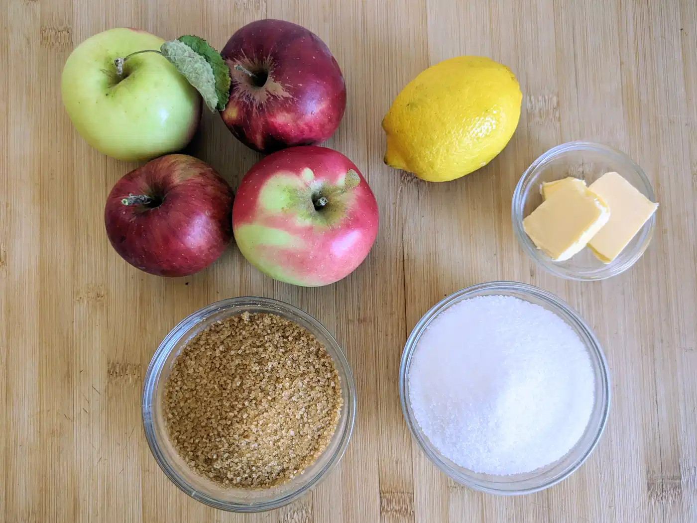 Apples, lemon, butter and sugar ready for cooking into toffee apple jam