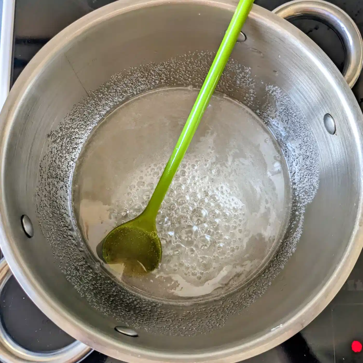 Bubbling sugar syrup with a green spatula