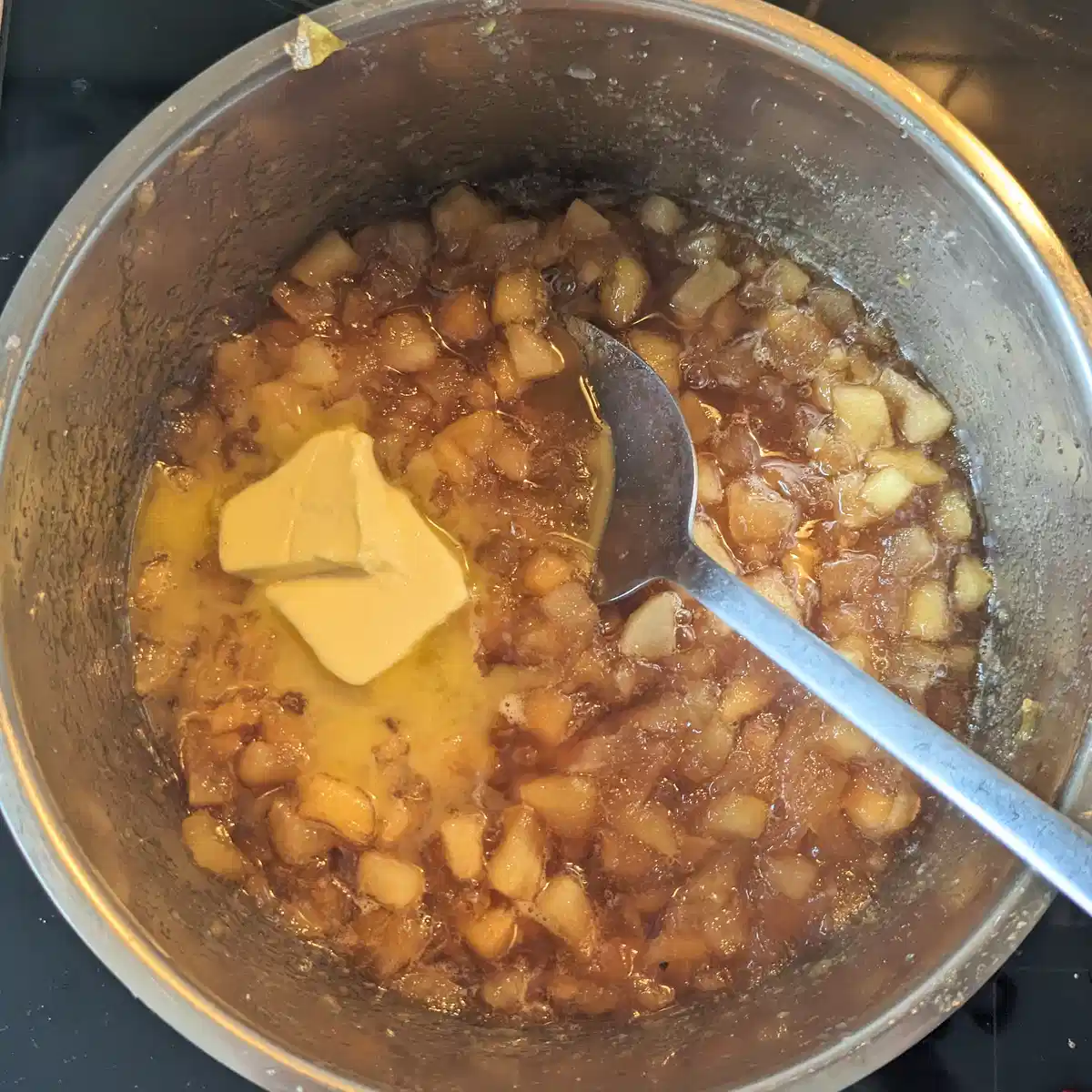 Butter added to toffee apple jam in a saucepan